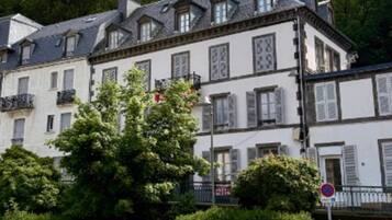 A multi-story building with a classic architectural style, featuring symmetrical windows and a balcony.
