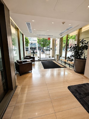 A modern hotel lobby with a reception desk, seating area, and large windows. - Waterfalls Hotel Ocean City Views Private Large Outdoor Patio 16th Floor 2bd/2ba (Victoria)