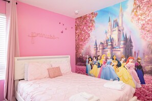 Ein Schlafzimmer in Rosa, mit einem Bett mit weißer Bettwäsche und einem großen Wandbild von Disney-Prinzessinnen.