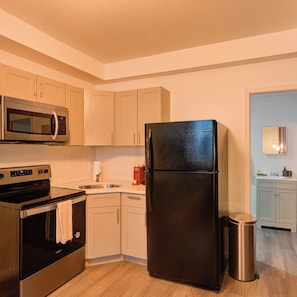Eine moderne Küche mit Edelstahlgeräten, einem Geschirrspüler und einem Mülleimer.