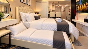 Een moderne slaapkamer met een groot bed, nachtkastjes, een spiegel en een televisie.