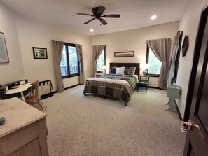 A bedroom with a bed, a desk, a chair, a ceiling fan, and a window with curtains. - Spacious Lakehouse on Lac Courte Oreilles (Stone Lake)