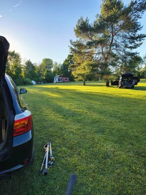 Un campo cubierto de hierba con un coche y un remolque.