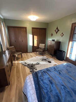 A bedroom with a bed, two chairs, a dresser, a wardrobe, and a rug. - The Coteau Chateau 3-bedroom country home near Conde awaits you (Conde)