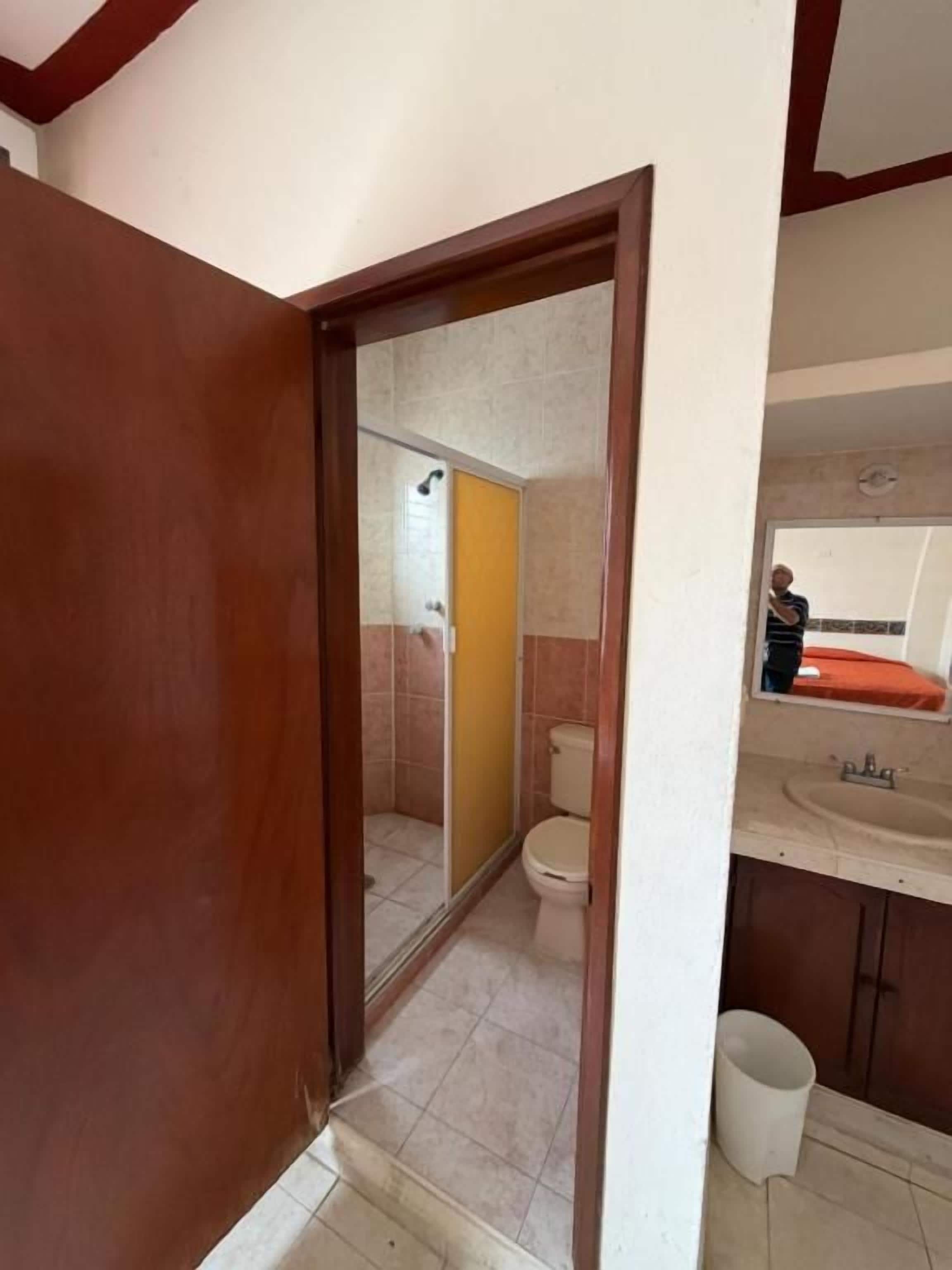 A bathroom with a shower, toilet, and sink.