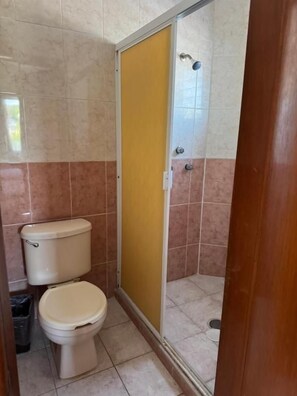 A bathroom with a toilet, a shower enclosure, and tiled walls. - Microhotel Ciudad del Carmen (Ciudad del Carmen)