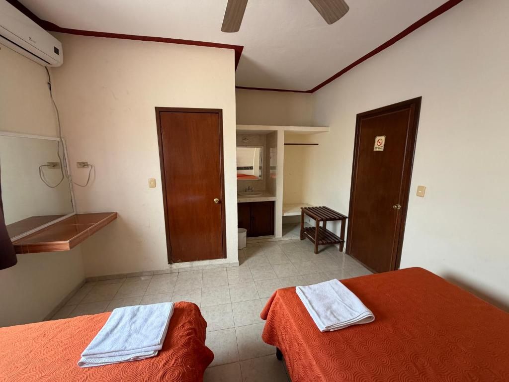Ein Zimmer mit zwei Betten, einem Schreibtisch und einem Kleiderschrank.
