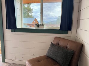 A room with a window, a brown chair, and a small potted plant on the windowsill. - Peaceful Mountain Retreat Near Durango with Beautiful Nature Views (Bayfield)