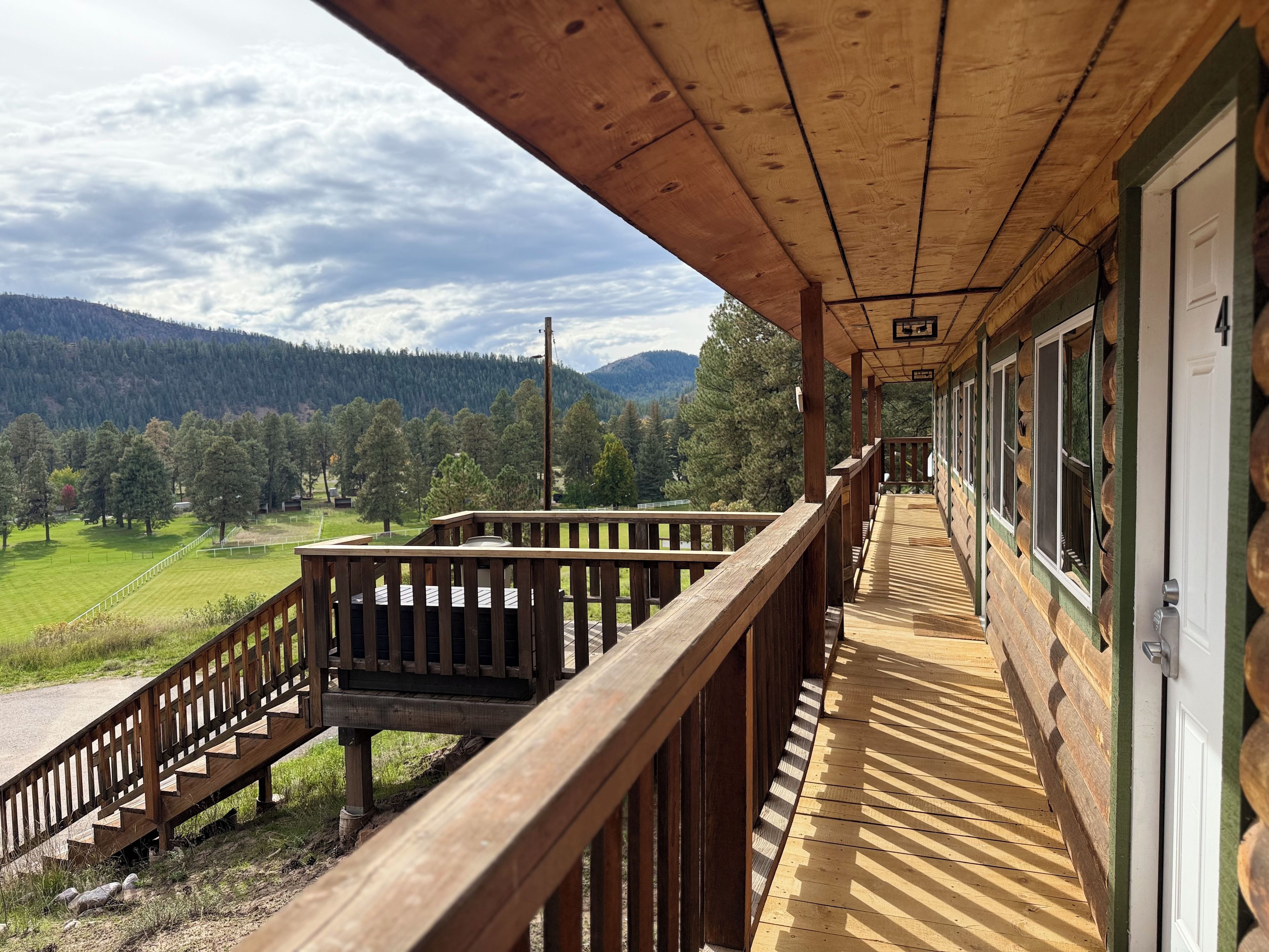 Una terraza de madera con vistas a un paisaje montañoso.