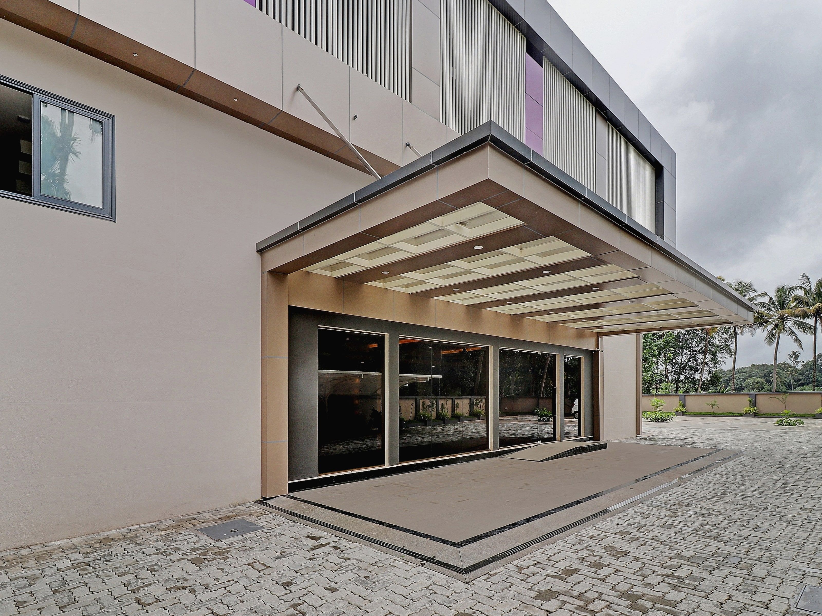 Un bâtiment moderne doté d’une entrée couverte et d’un espace extérieur aménagé.