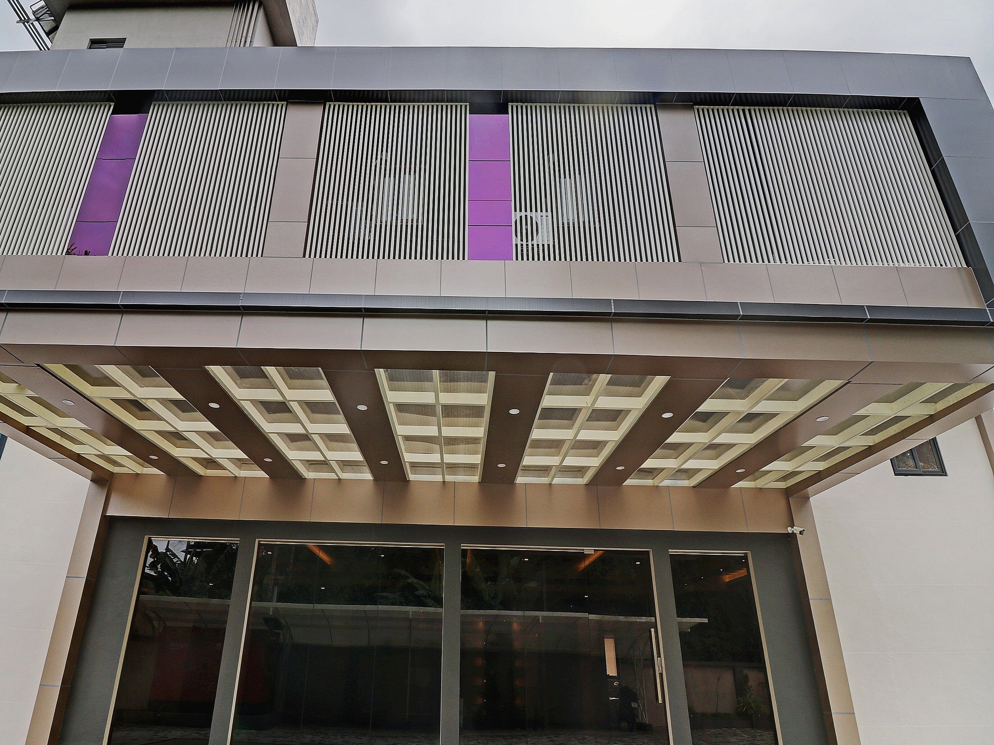 Un edificio de diseño moderno, con techo plano, ventanas grandes y fachada estampada.