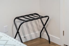 A black metal drying rack against a white wall with a wooden floor. - 13 mins to Campbell University Boho Retreat (Angier)