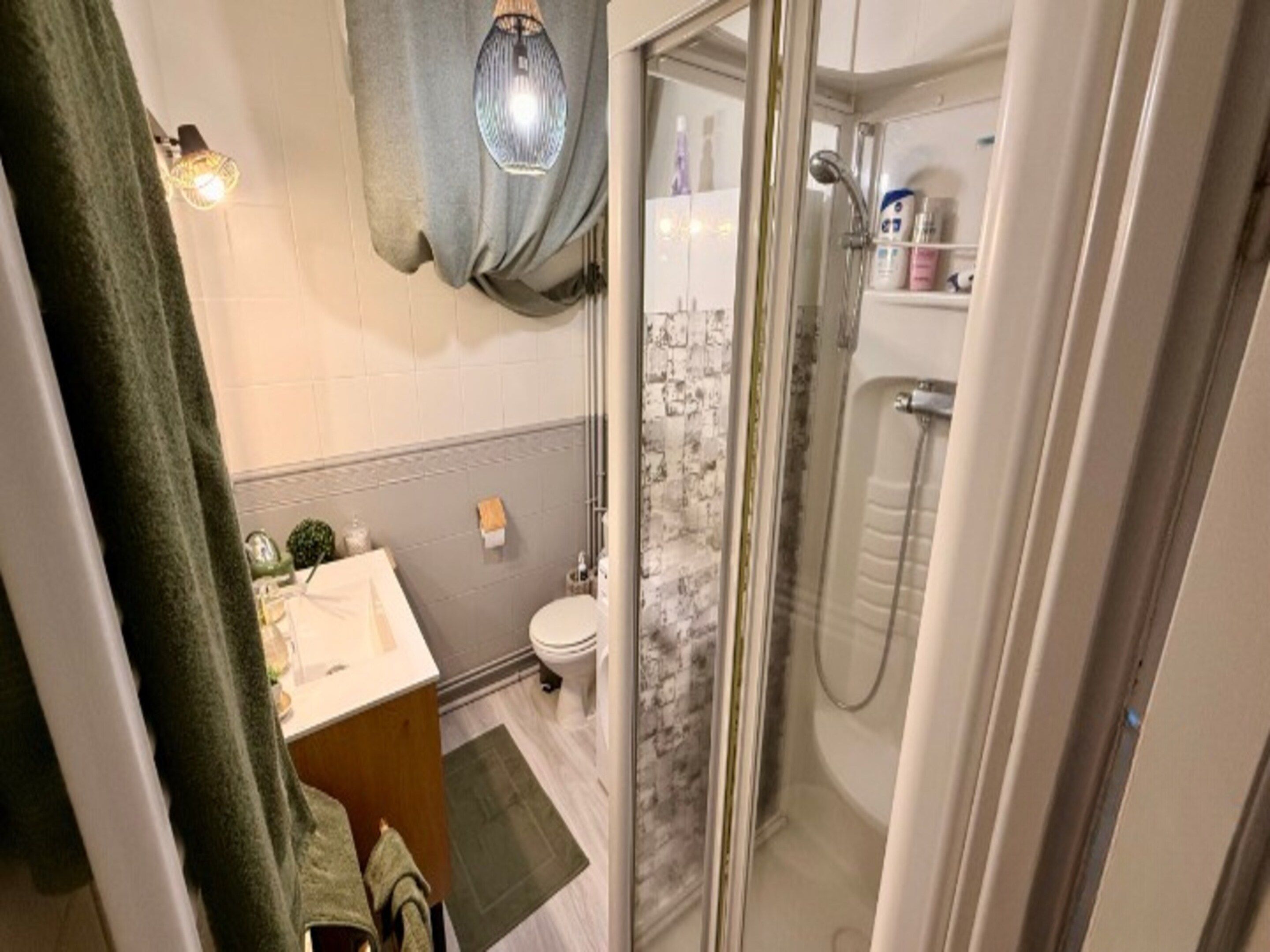 A bathroom with a shower, toilet, and sink.