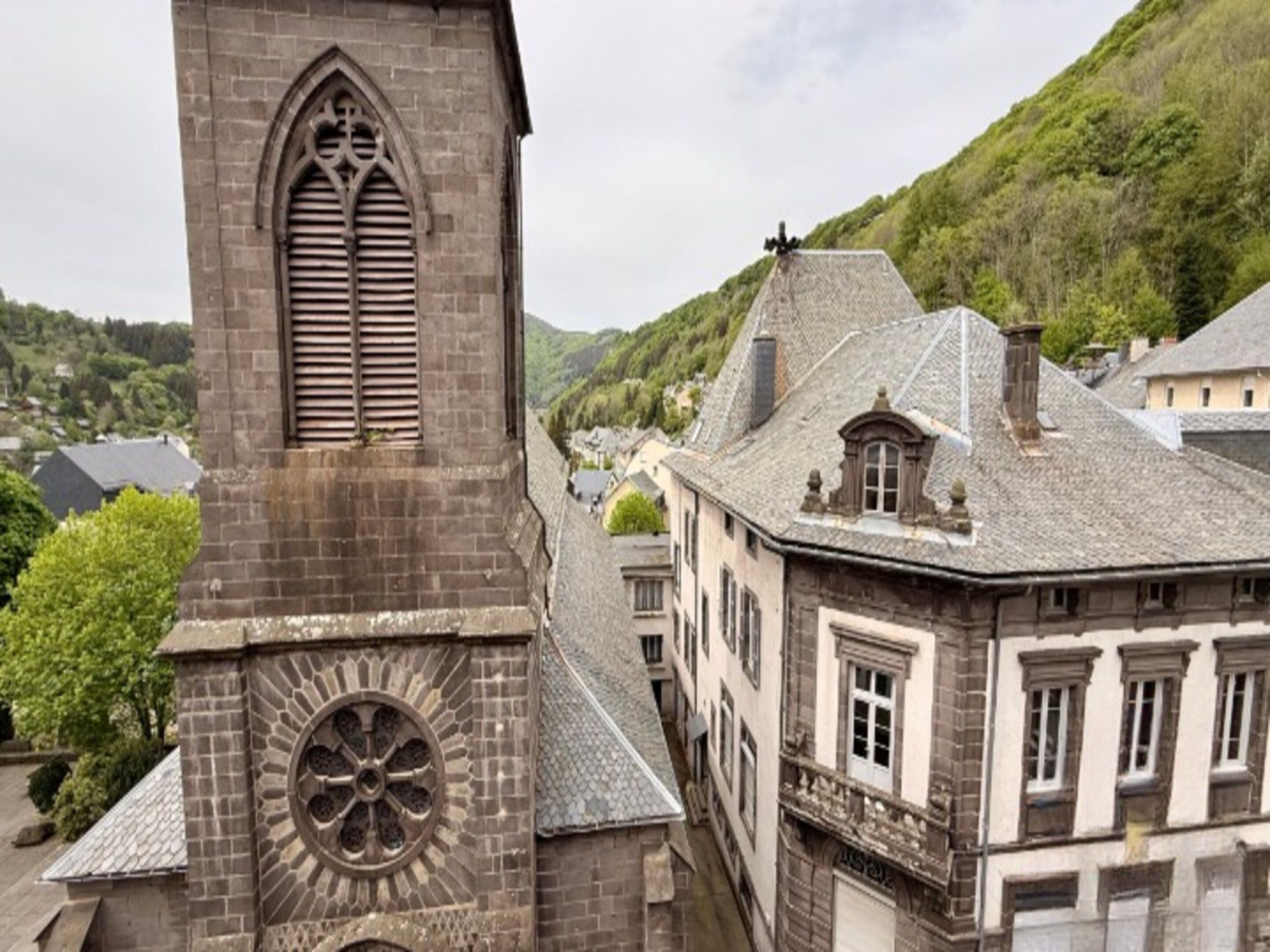A historic building with a prominent clock tower and a narrow street.