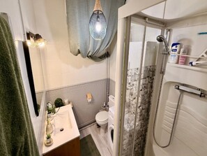 Ein Badezimmer mit Dusche, Toilette und Waschbecken.
