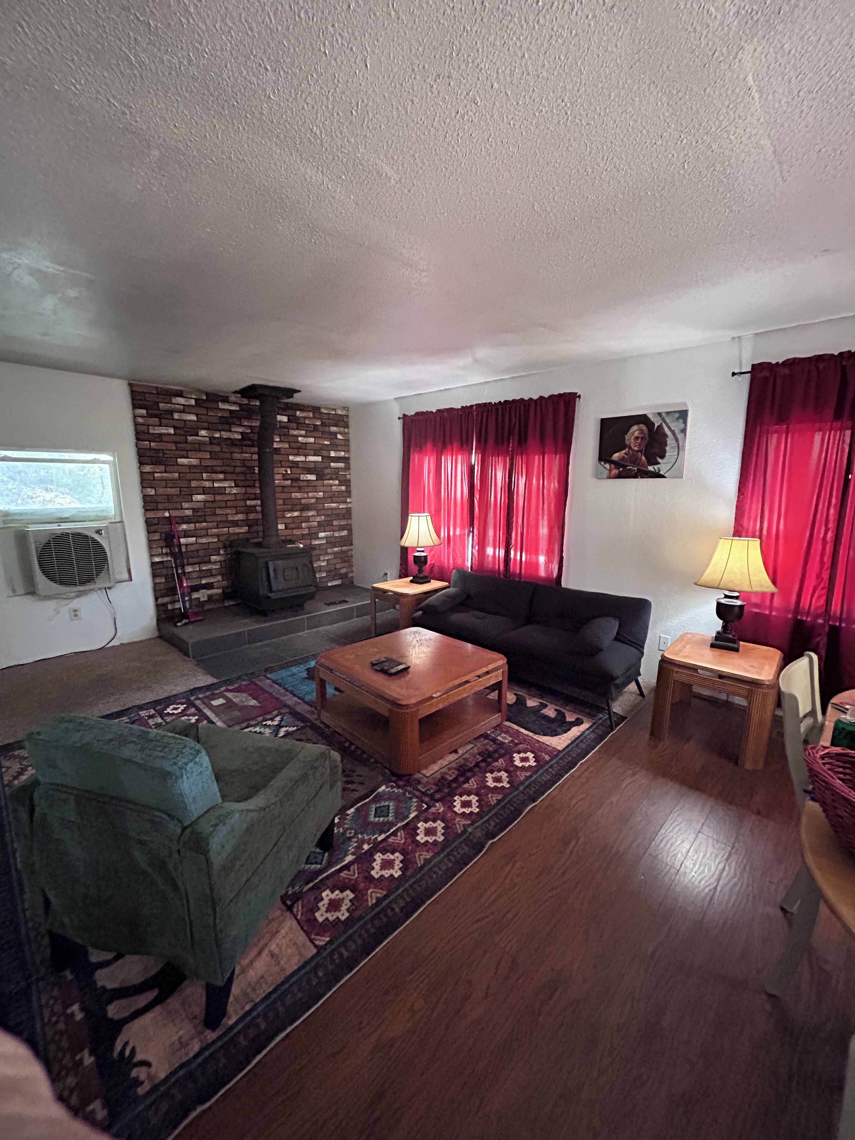 A living room with a sofa, a coffee table, a television, and a fireplace.