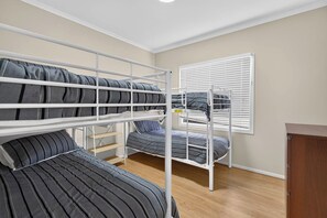 A bunk bed room with a wooden floor, a white wall, and a window with blinds. - 9 Barbara Street, Port Elliot Near Horseshoe Bay & Greenbay (Port Elliot)