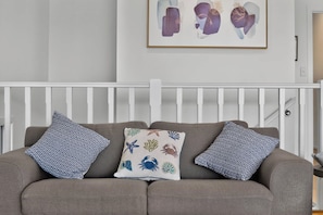 A grey sofa with patterned cushions and a framed abstract painting above it. - 9 Barbara Street, Port Elliot Near Horseshoe Bay & Greenbay (Port Elliot)