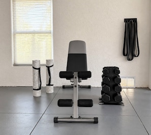 A gym with a bench press, dumbbells, and resistance bands. - Waterfront Home w/ Pool and Kayaks near Beaches (Hernando Beach)