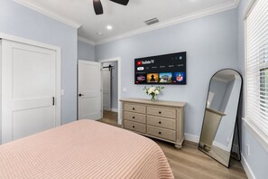 A bedroom with a bed, dresser, mirror, and a wall-mounted TV displaying YouTube TV interface. - Waterfront Home w/ Pool and Kayaks near Beaches (Hernando Beach)