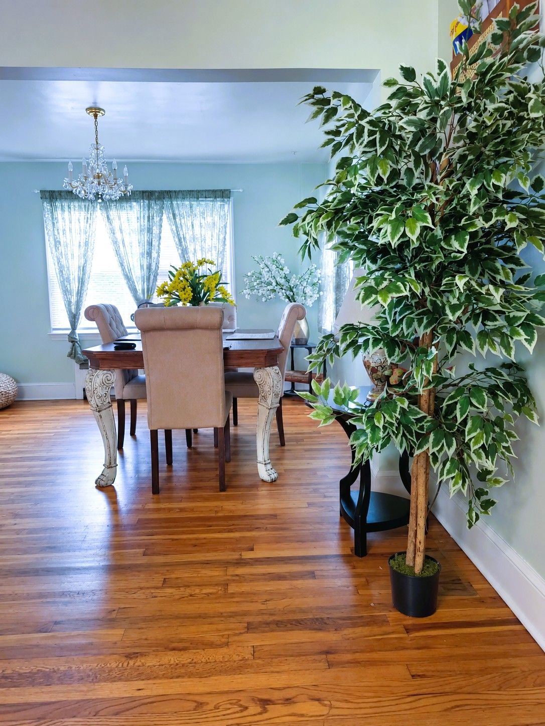 A dining area with a wooden table, chairs, and a chandelier.