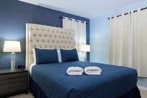 Ein Hotelzimmer mit einem großen Bett, zwei Nachttischlampen und einer digitalen Uhr.