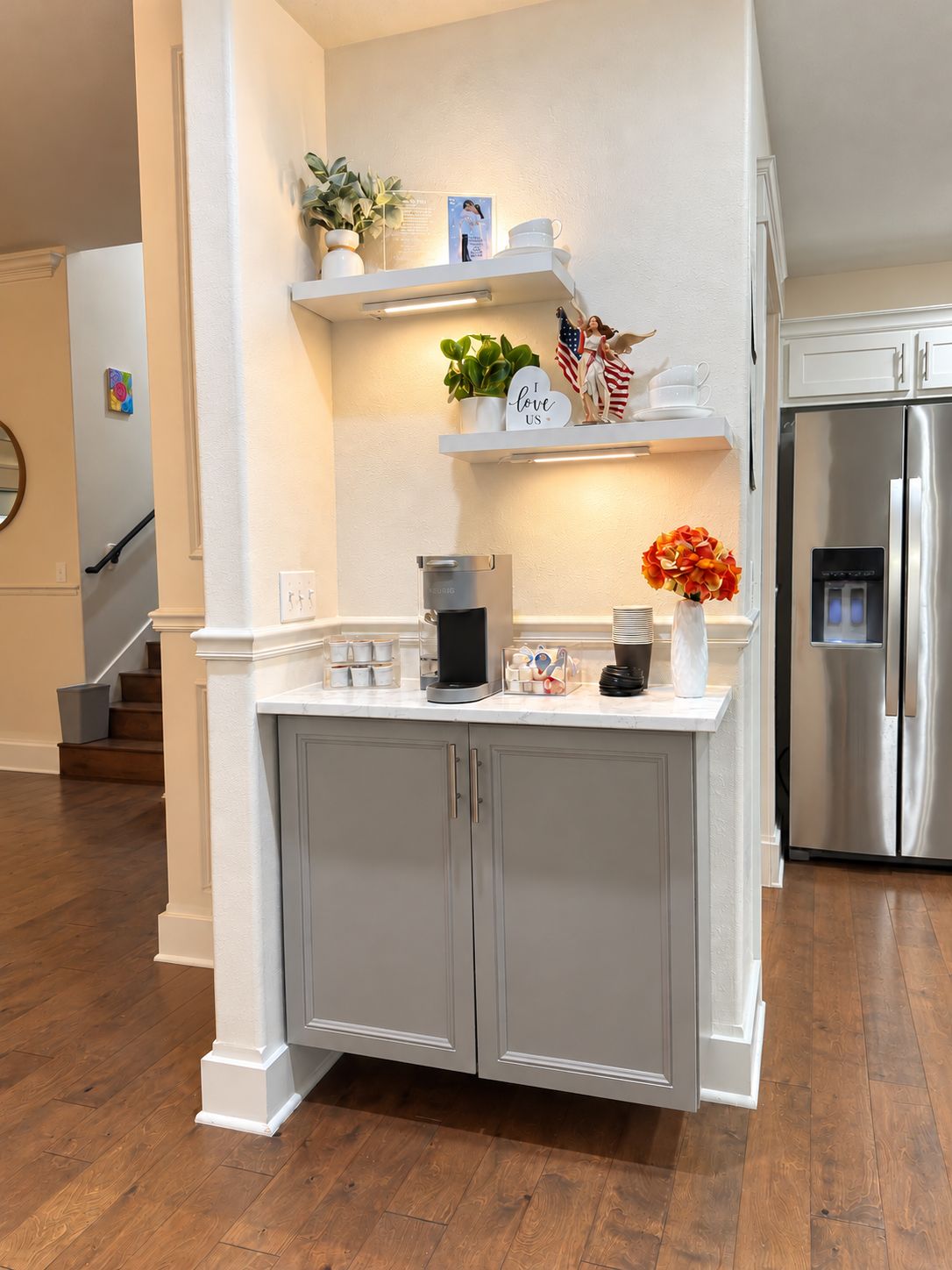 A kitchen with a built-in refrigerator, white cabinetry, and a countertop with various items.