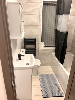 Une petite salle de bain comprenant des toilettes, un lavabo et un espace douche.