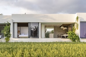 A modern house with a large glass door leading to a bedroom and a dining area. - OriVista 2BR Private Pool Villa w/ Rice FieldView (Ubud)
