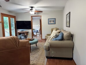A living room with a sofa, a television, a ceiling fan, and a view of the outdoors. - Quiet and Spacious 4-bedroom house in Ringgold...great for families! (Ringgold)
