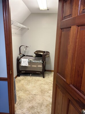A room with a crib, a wall-mounted shelf, and a door. - Quiet and Spacious 4-bedroom house in Ringgold...great for families! (Ringgold)