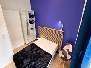 A bedroom with a bed, a wardrobe, and a bedside table. - Apartment Near Parc Fenestre (La Bourboule)