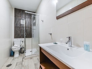 A modern bathroom with a glass-enclosed shower, a white sink, and a toilet. - Apartment Near Plaza de Espana, Madrid (Madrid)