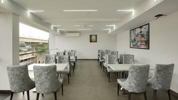 A spacious dining area with high ceilings, modern lighting, and a view of the cityscape.