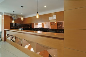 A reception desk with a counter, a fan, and a sign indicating it's a tourist home. - Super Townhouse Edasserys Kalamassery (Kanayannur)
