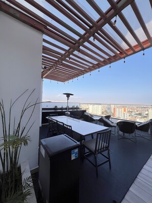 A rooftop terrace with a pergola, outdoor seating, and a view of the cityscape. - Vrbo Property (Barranco)