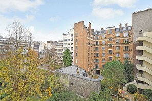 Ein mehrgeschossiges Wohngebäude mit Ziegelaußenwand, mehreren Balkonen und unterschiedlichen Fenstermustern.