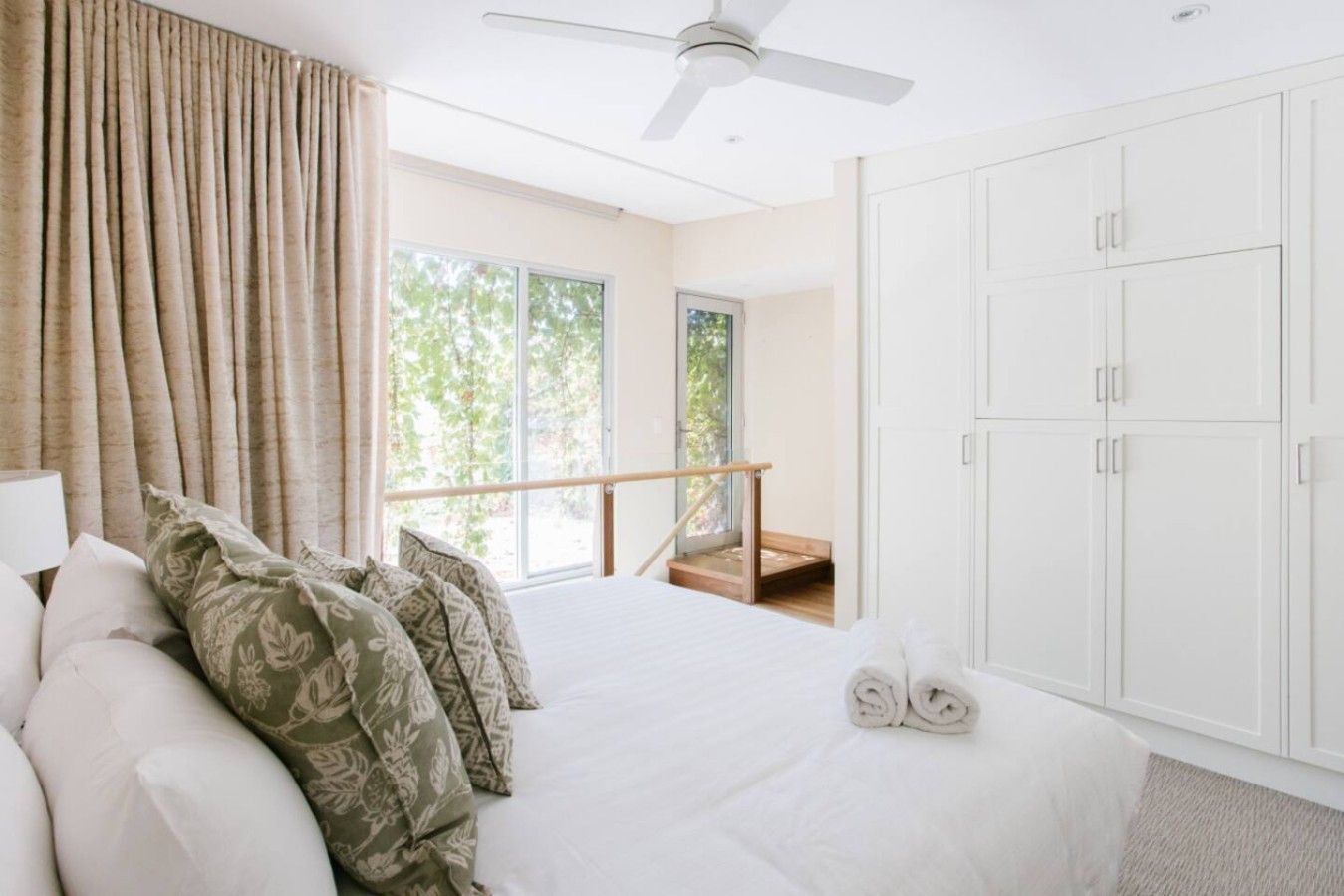 Un dormitorio con cama, balcón y armario.