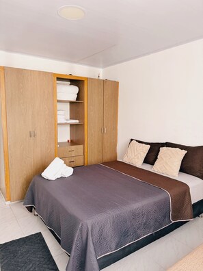 A bedroom with a bed, a wardrobe, and a bedside table. - Sariebay 3 Condo (San Andrés)