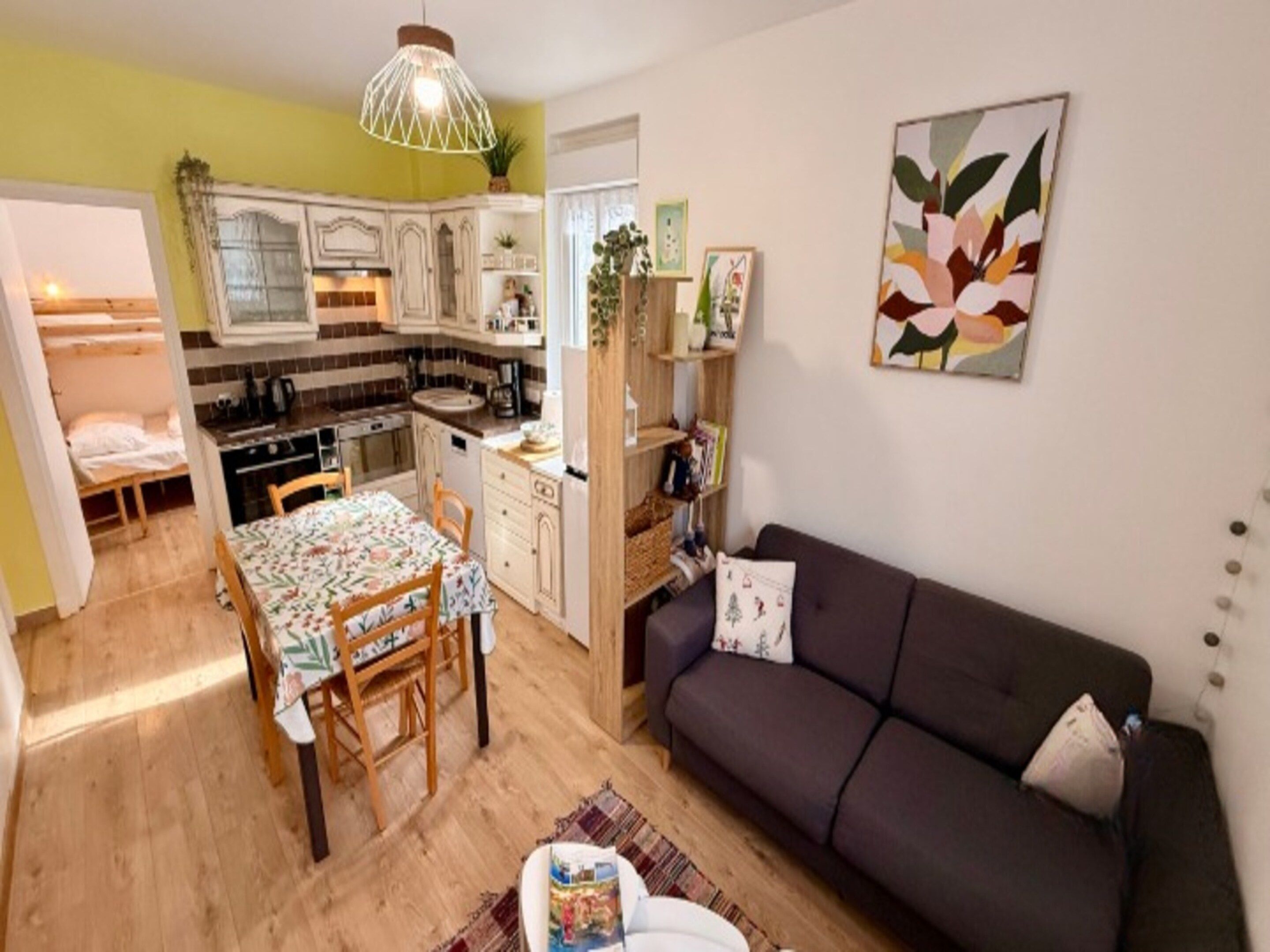 A compact living space with a kitchenette, dining area, and a sofa.