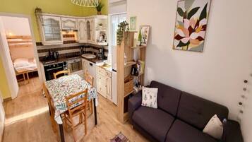A compact living space with a kitchenette, dining area, and a sofa.