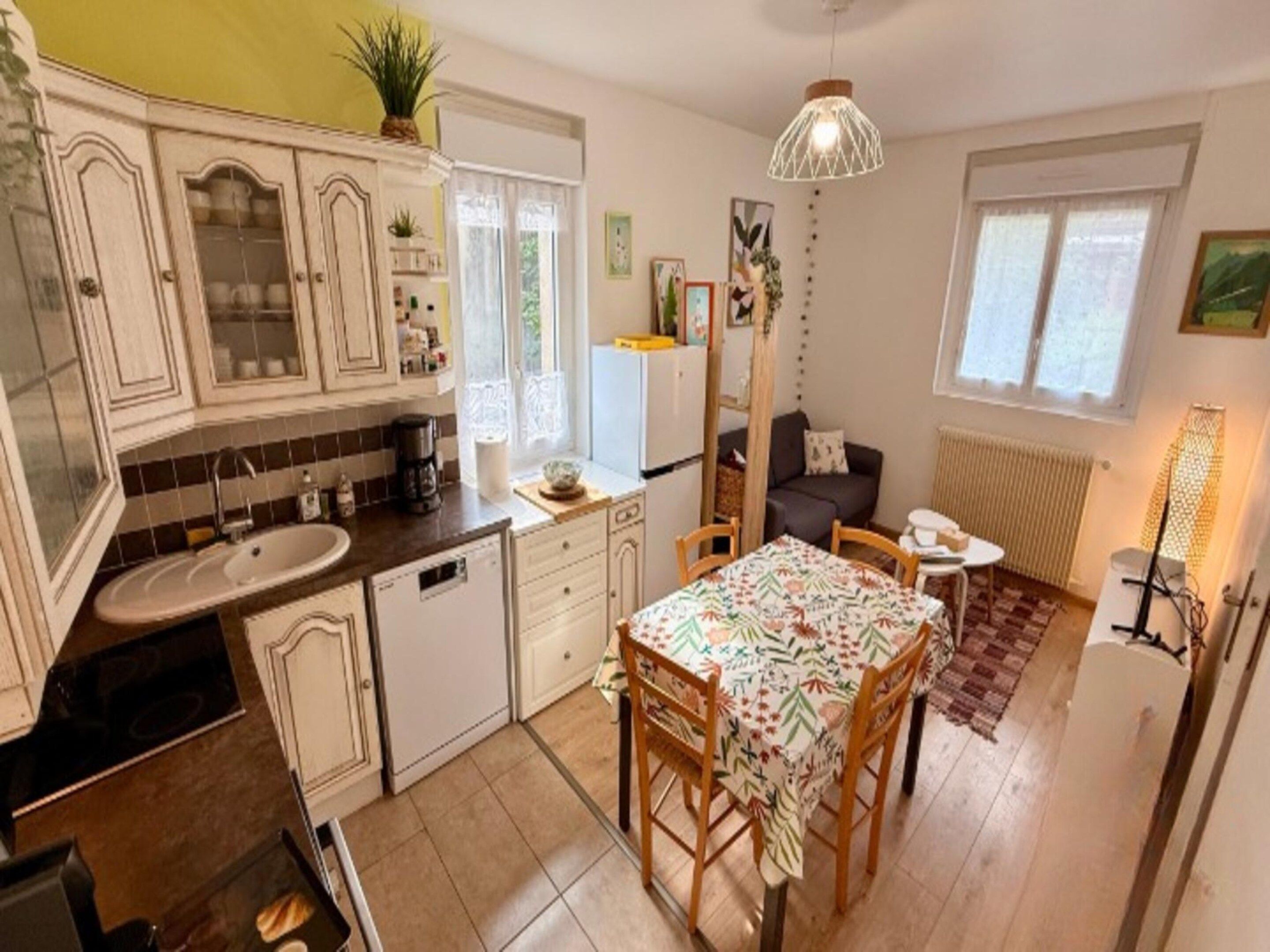 A compact kitchen with a sink, stove, and dining area with chairs.