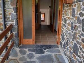 A stone-floored corridor with wooden doors and a metal gate. - Apartment 3 rooms 8 Pax, Tennis, Fireplace, Views & Pet-Friendly (Ger)