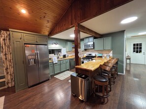 A kitchen with a central island, stainless steel appliances, and a wooden ceiling. - Quiet Waterfront Cabin, Private Dock, Fire Pit, Pet Friendly (Parsons)