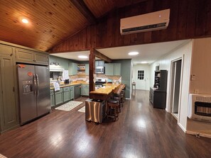 A modern kitchen with a central island, stainless steel appliances, and a wooden ceiling. - Quiet Waterfront Cabin, Private Dock, Fire Pit, Pet Friendly (Parsons)