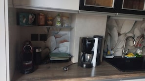 A kitchen with a coffee maker, a kettle, and a sink. - Alimos Signature Home (Alimos)