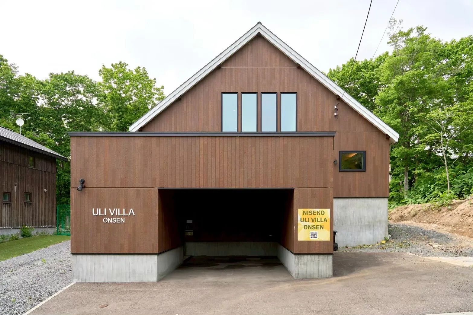 A modern building with a garage entrance, labeled 'ULI VILLA ONSEN.'