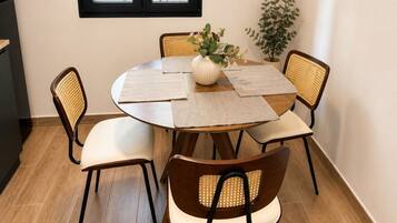 Un comedor con una mesa redonda, cuatro sillas y una planta en maceta.