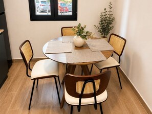 Un comedor con una mesa redonda, cuatro sillas y una planta en maceta.