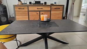 Ett matbord med en svart bordsskiva och en ljusstake i mitten.